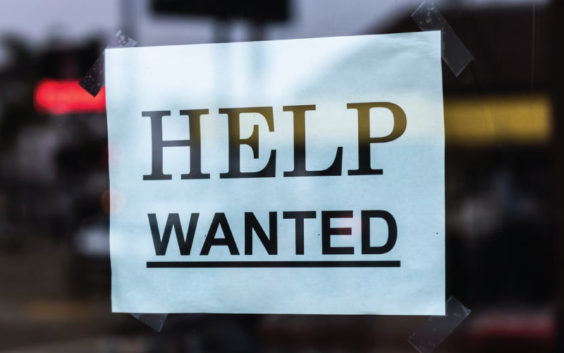 A help wanted sign sits in a doorway as worker shortages persist.