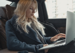 An executive traveler sits in the back seat of AFIMAC secure transportation services after calling upon corporate travel risk management solutions.