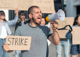 Labor disputes shown via a worker shouting into a megaphone.