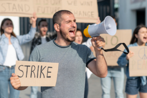 Labor disputes shown via a worker shouting into a megaphone.