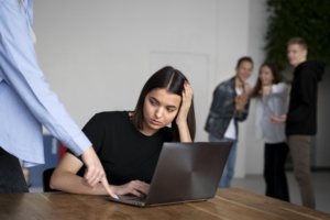 Workplace violence prevention services show by a worker being bullied in an office setting.